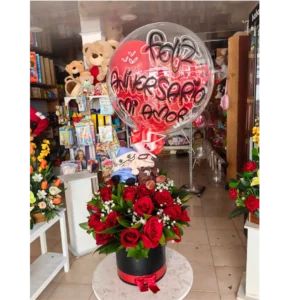 Caja cilíndrica con rosas rojas, globo “Feliz Aniversario” y peluches en Pereira