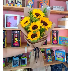 Bouquet engalanado de girasoles frescos envueltos en papel kraft con follaje verde