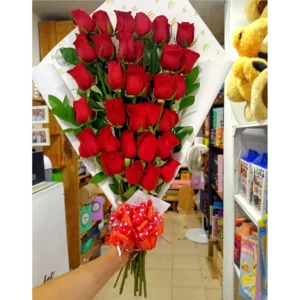 Bouquet engalanado de 30 rosas rojas envueltas en papel decorativo con moño rojo