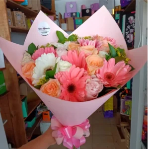 Bouquet de 24 flores surtidas con rosas y gerberas en tonos pastel envuelto en papel rosado