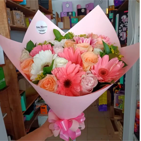 Bouquet de 24 flores surtidas con rosas y gerberas en tonos pastel envuelto en papel rosado