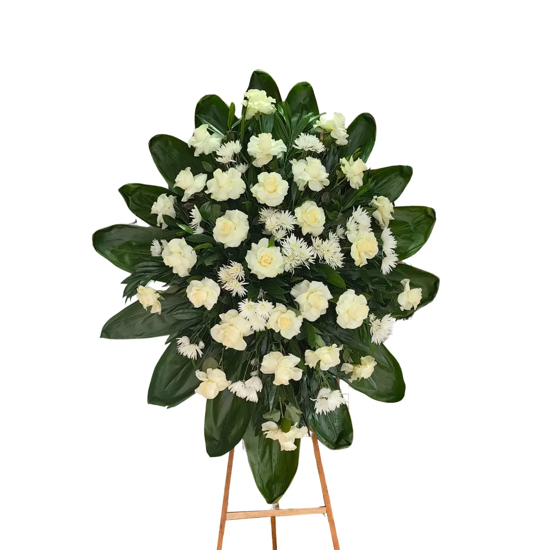 Arreglo floral de condolencias con flores blancas y follaje verde