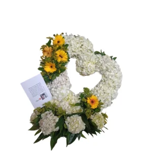 Corona floral de condolencias con flores blancas y detalles amarillos