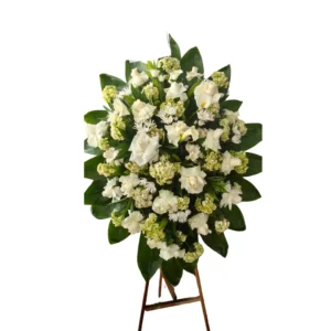 Arreglo floral de condolencias con flores blancas y follaje verde